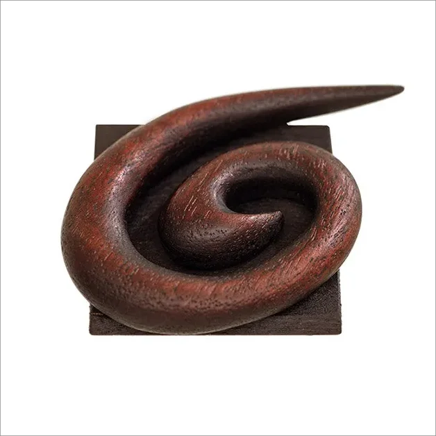 Curved wooden sculpture on base.